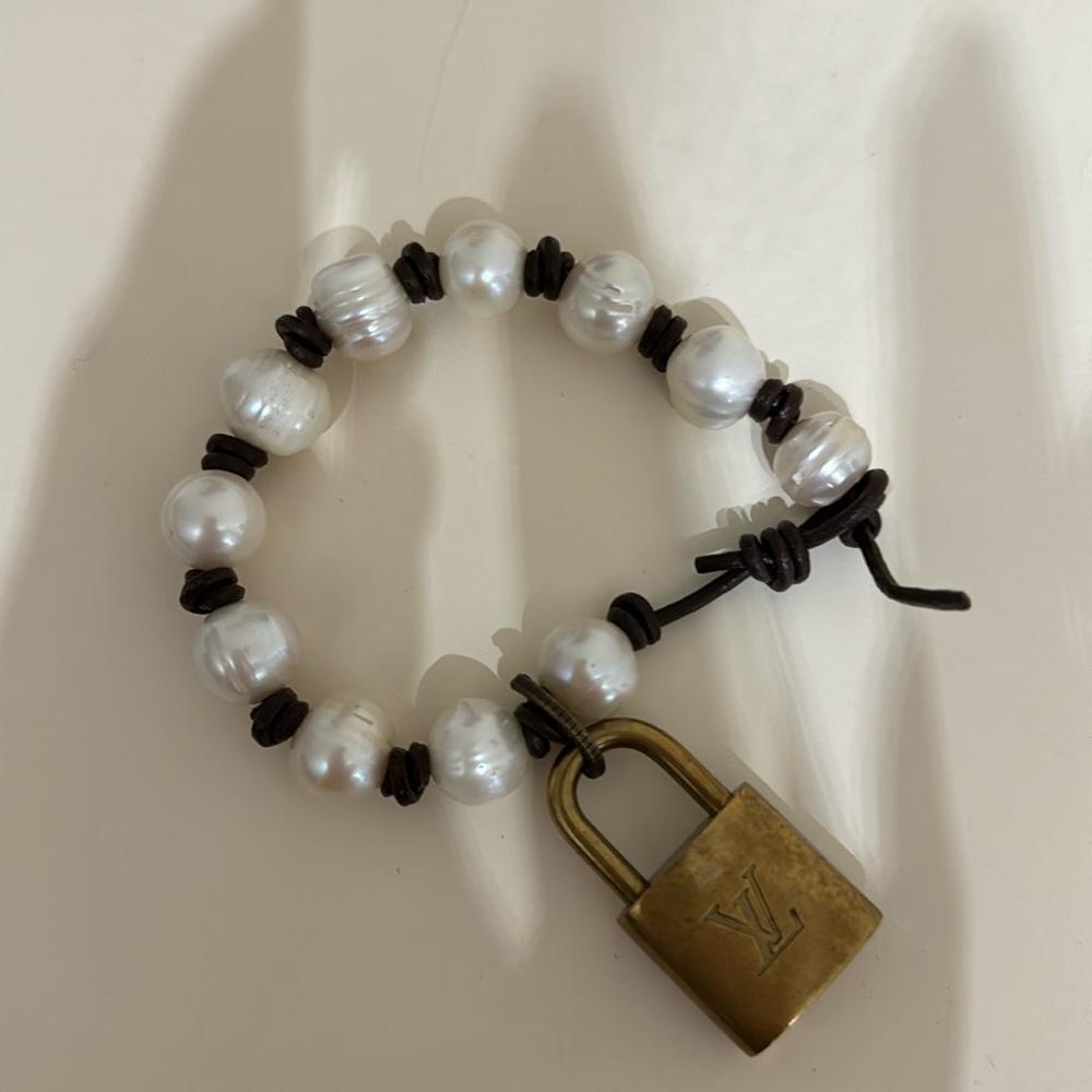 Pearl and leather bracelet with Louis Vuitton lock.